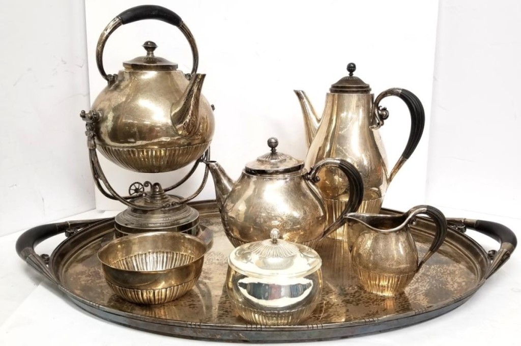 A Georg Jensen Cosmos sterling silver six-piece tea/coffee service set included serving tray, water kettle with burner stand, tea kettle, coffee pot, creamer, sugar and waste. All had black wooden handles of ebony. The set brought $15,375.