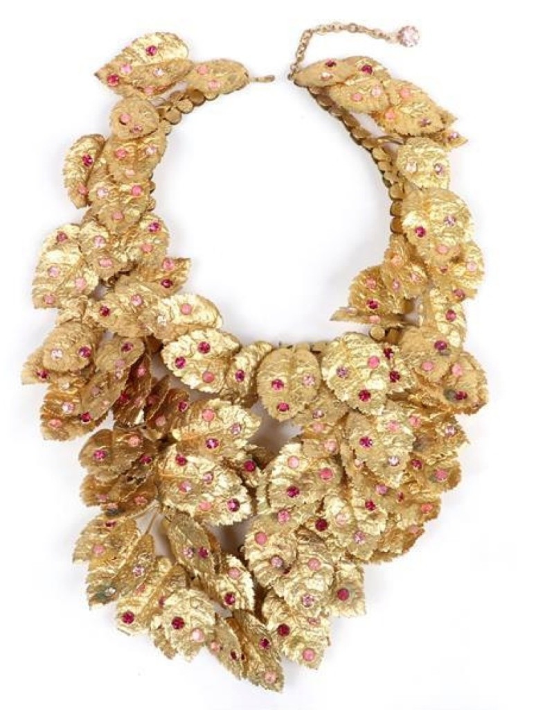 A 1930s-40s gilt-brass layered leaf bib necklace with pink and red rhinestones and embossed texture took $1,500.