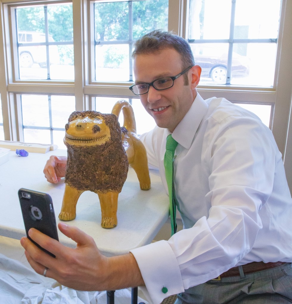 Daniel Ackermann taking a selfie with MESDA’s iconic Solomon Bell lion   during the installation of the William C. and Susan S. Mariner   Southern Ceramics Gallery in 2015. —Robert Hunter photo.