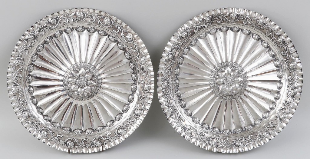 This pair of large Eighteenth Century English sterling silver sideboard chargers with scalloped edges, floral repousse and sunflower centers commanded $4,200.