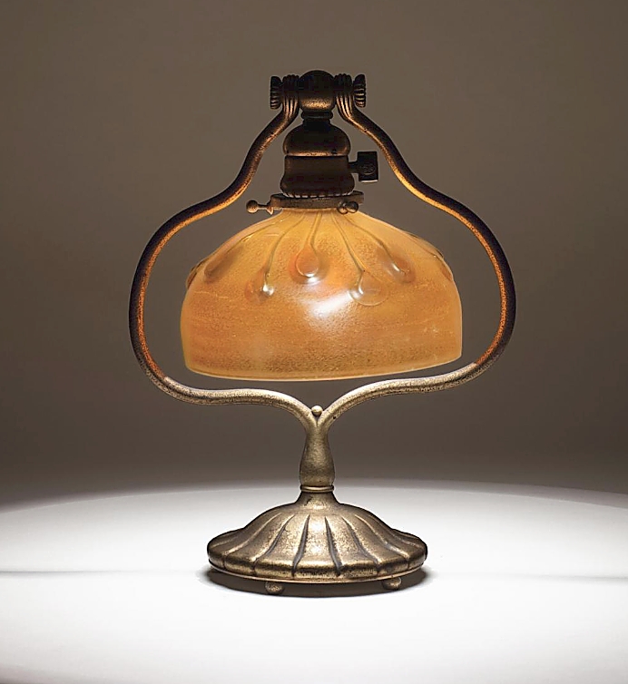 Lilian Nassau LLC, New York City, sold this Tiffany Studios favrile glass harp lamp, 13 inches high and circa 1900-19. The shade was in a gold iridescence with a series of applied lily pads, mounted on a gilded bronze base.