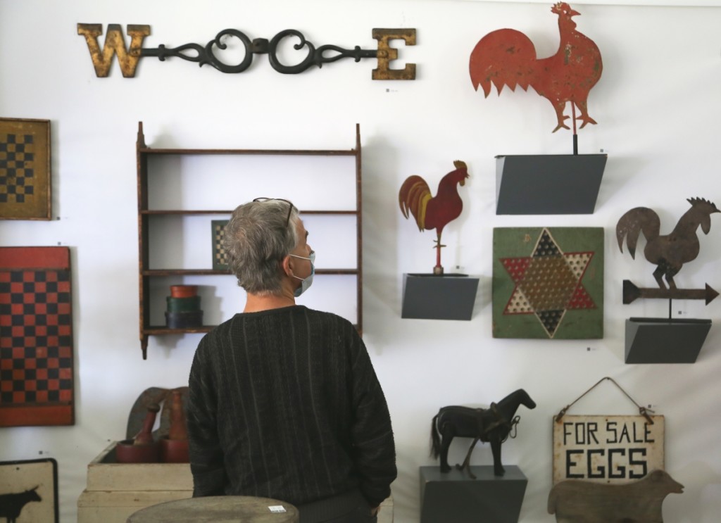 A buyer checks out the offerings in the booth of Missouri Plain Folk, Sikeston, Mo. —Antiques At Fletcher Fields