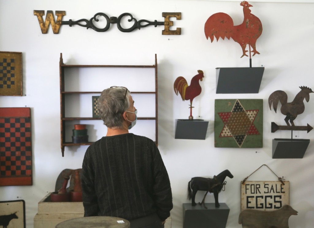 A buyer checks out the offerings in the booth of Missouri Plain Folk, Sikeston, Mo.           —Antiques At Fletcher Fields