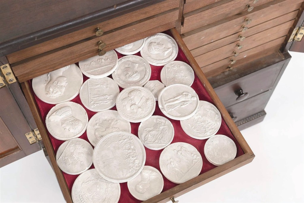 Grand Tour plaster intaglios in an English mahogany veneer cabinet were bid to $2,875.