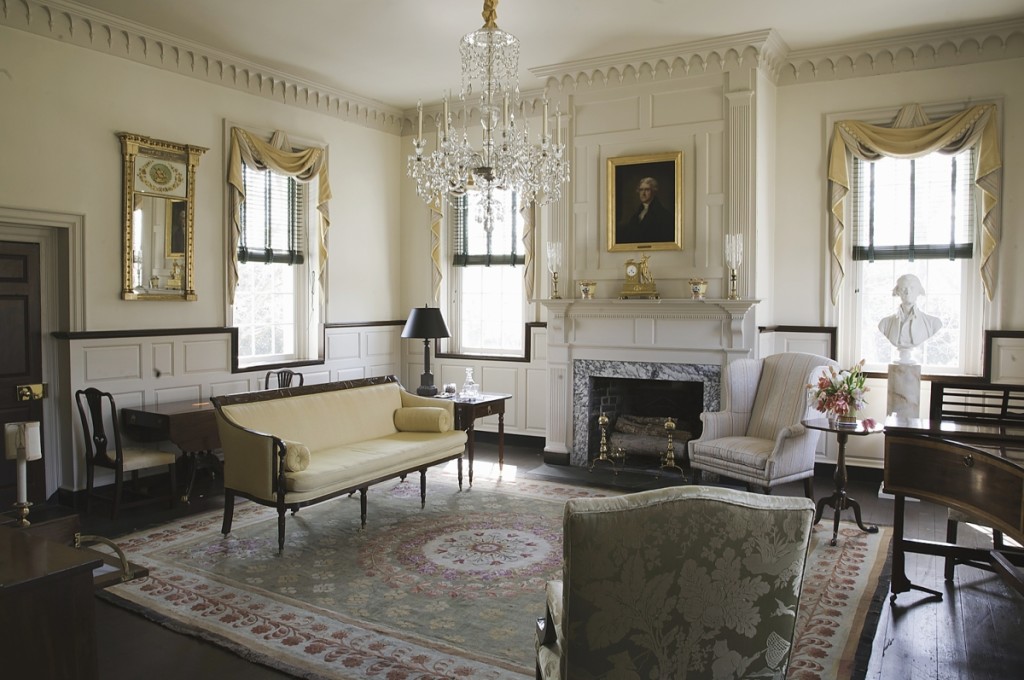 The Music Room at Ayr Mount. The portrait of Thomas Jefferson over the mantel is an early Nineteenth Century depiction by Ezra Ames after Gilbert Stuart. The sofa is by Duncan Phyfe. Partially visible at right is the Kirkland family’s John Broadwood & Son piano, one of the original Kirkland family objects Jenrette was able to bring back to Ayr Mount. The elaborate mantel is attributed to joiner Elhannon Nutt of Wake County.