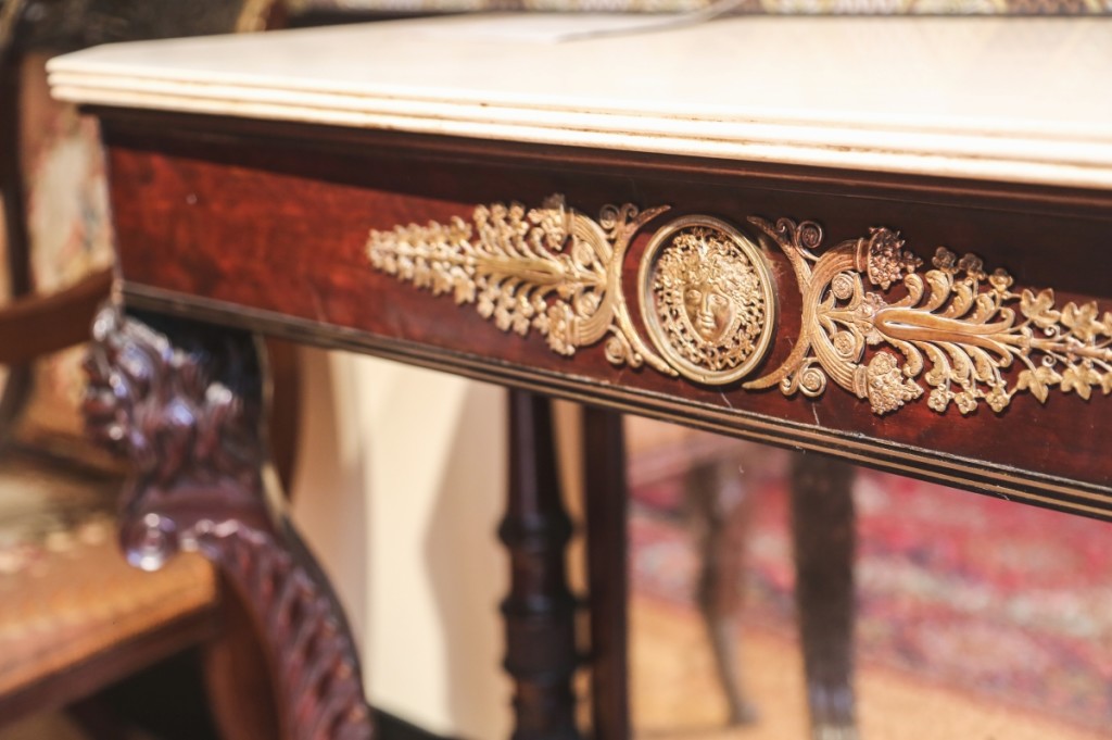 A detail of the central gilded mount on a marble top table attributed to Duncan Phyfe.