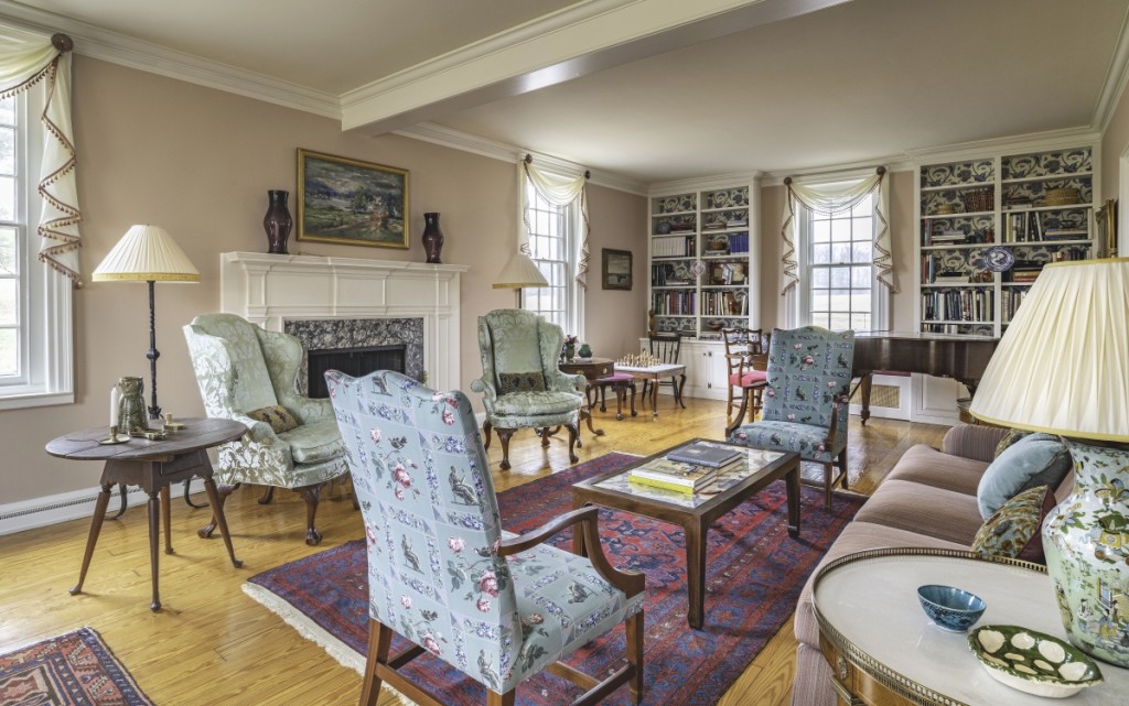 “I wanted the living room at Chandler Farm to be as suitable for the Cadou children as for a cocktail party,” says Jayne, who combined family furniture with study objects and reproductions that had been scattered around the estate. Cadou salvaged the discarded green silk on the wing chairs from a previous project. Photo James Schneck.