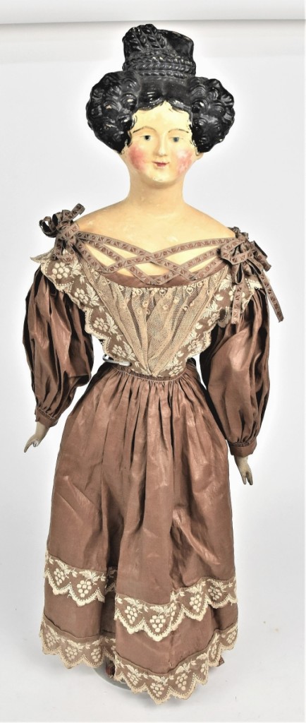 A German papier mache shoulder head doll, circa 1840s, went out at $5,220. The auction house said it had its original glazed brown cotton gown with embroidered lace trim and original undergarment. Dingus collection.