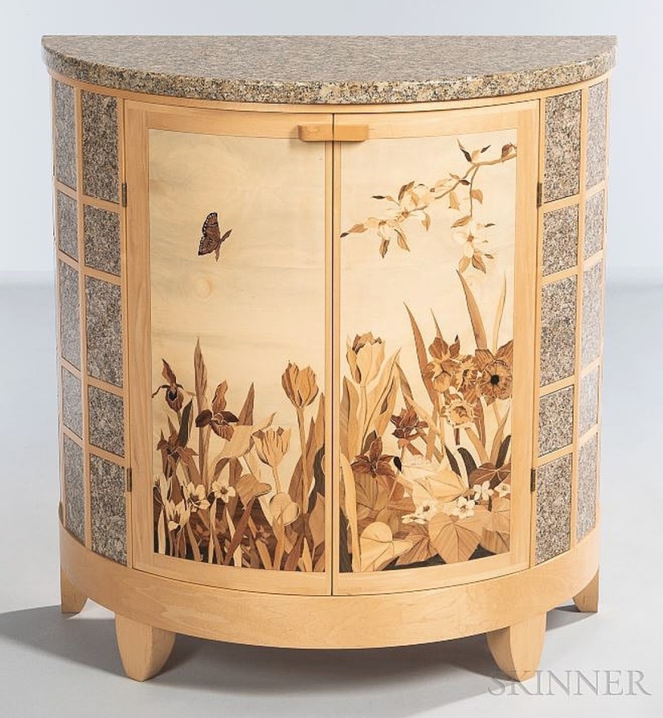 Contemporary studio furniture maker Silas Kopf was the recipient of a 1988 Craftsman’s Fellowship from the National Endowment for the Arts, which he used to study traditional marquetry methods at the École Boulle in Paris with Pierre Ramond. This demilune cabinet features a marble top and side panels surrounding a natural scene of flora and a flying butterfly. The circa 2010 example, in maple, holly and other woods, brought $16,250.