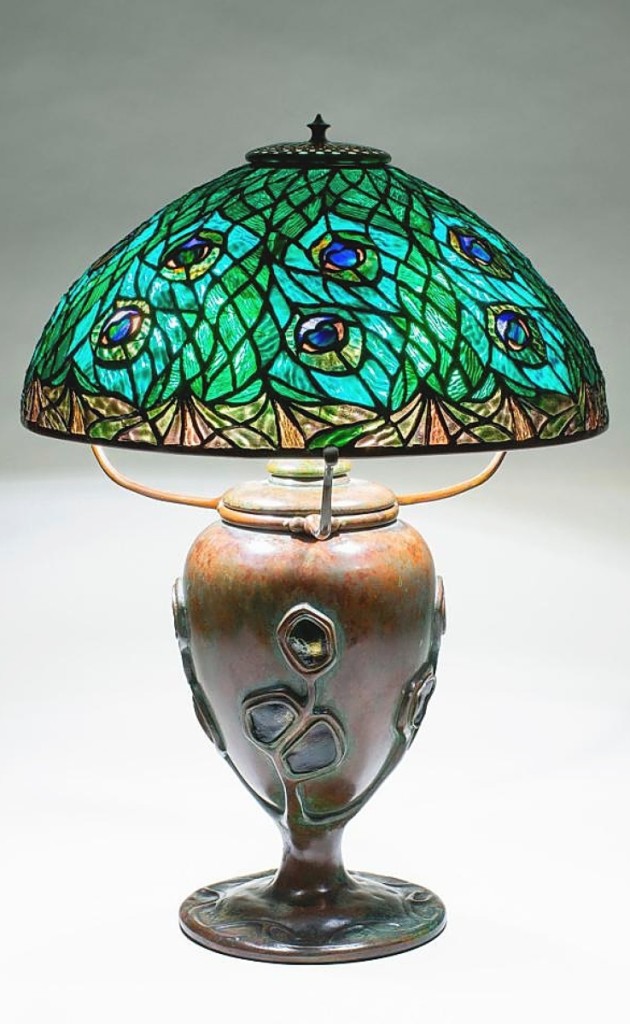 Table lamp by Tiffany Studios, 1902-04, with Peacock shade and patinated bronze base inset with original Tiffany turtle-back tiles. Lillian Nassau, Ltd.