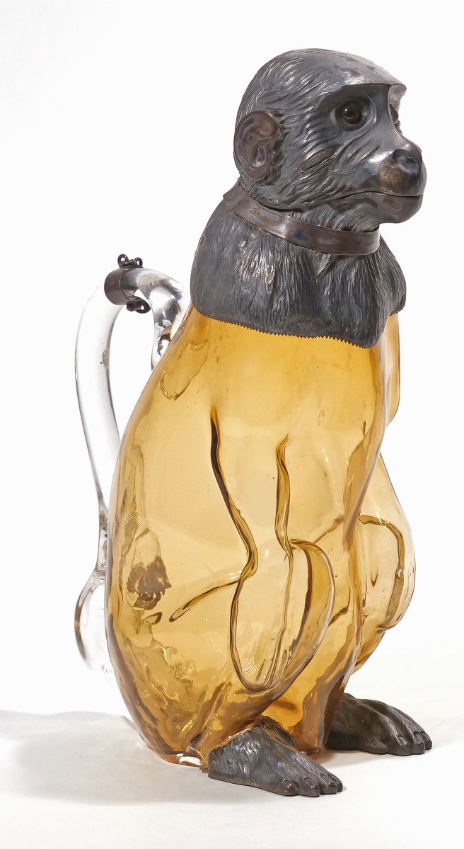 An important English silver and blown glass claret jug was in the form of a crouching monkey. Rare with blown amber glass body and silver head, shoulders and feet, hinged head with collar and two-tone glass eyes, it was made in London, circa 1893, with silver mounts by Richard Hodd & Sons. The 11½-inch-high jug sold for $14,640.