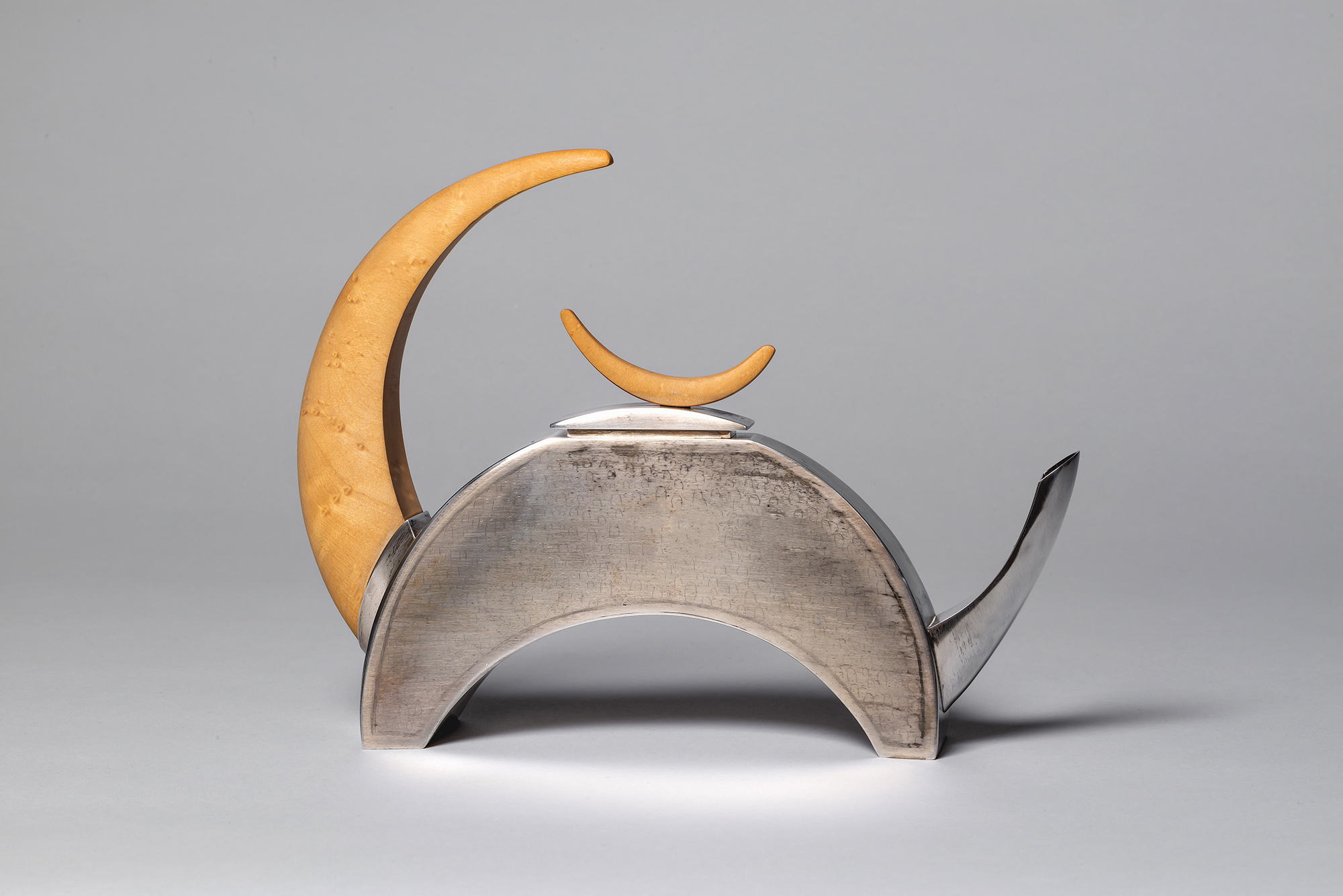 “Subtle-tea” by Michael Massie (Happy Valley-Goose Bay, b 1962), 1997. Silver, wood. Collection of the Winnipeg Art Gallery, gift of the Canadian Museum of Inuit Art, 2017-564. Courtesy Qaumajuq at the WAG.