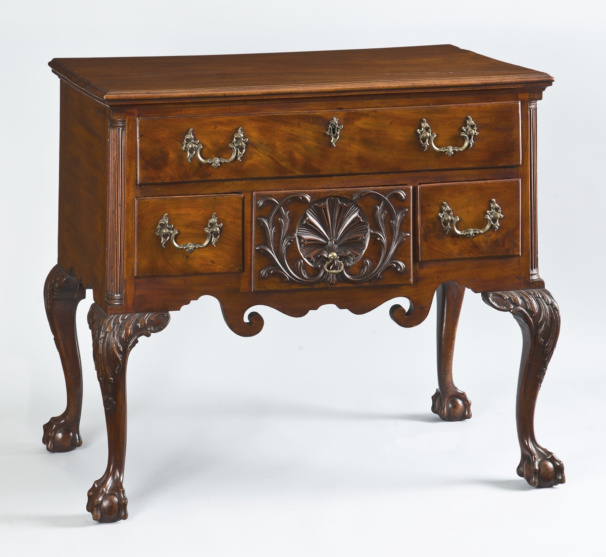 Philadelphia mahogany dressing table attributed to the workshop of cabinetmaker Benjamin Randolph, incorporating the latest fashion of fluid and robust carving attributed to the London emigre carver Hercules Courtney. This table has the finest quality of highly figured mahogany and is further ornamented by its original rococo brass hardware, a rare level of embellishment. Descended in the Wistar family of Philadelphia. Circa 1770. Philip Bradley Antiques.