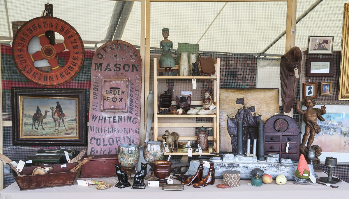 Variety was on hand with Evergreen Antiques out of Detroit. The dealer featured a trade sign order box, carvings, pottery, a game wheel and more.