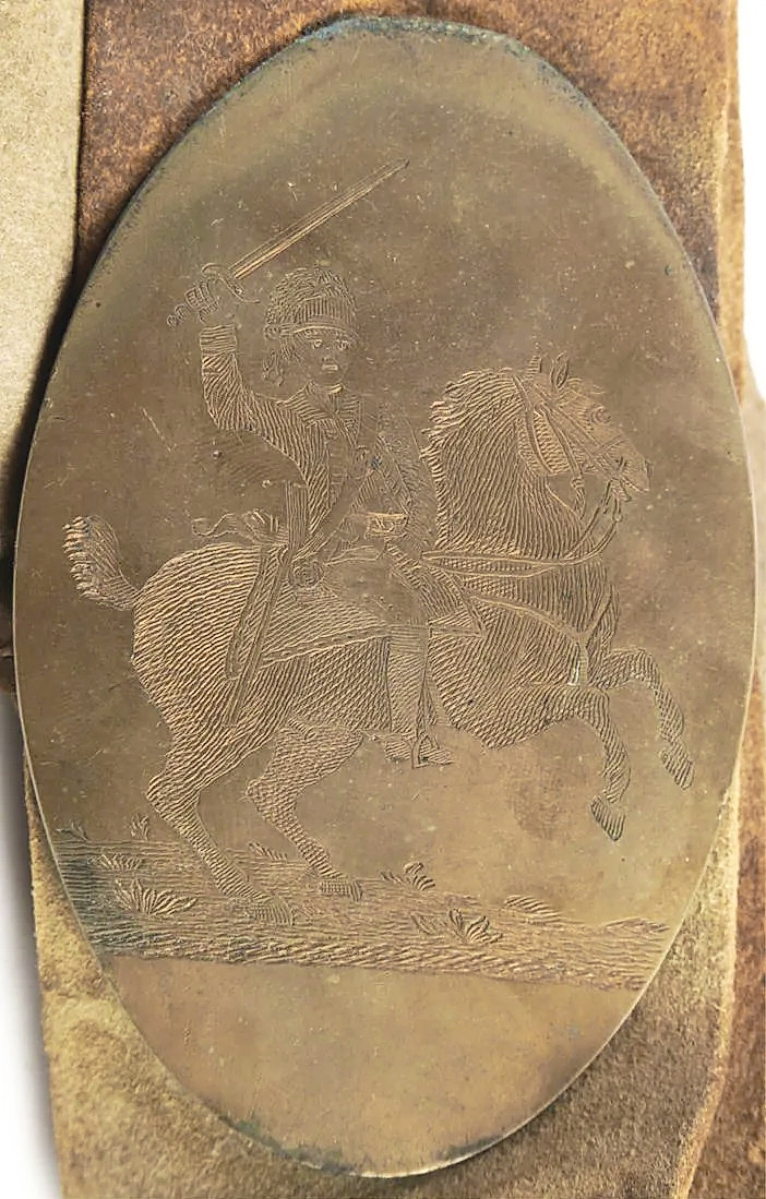 The sale found its leader at $22,140 with a leather military strap featuring a brass badge engraved with a cavalry officer on horse rampant.