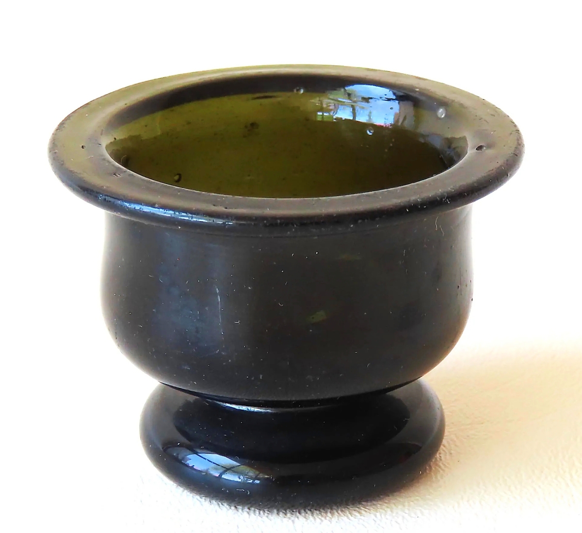 Leading all lots of American glass was this urn-form salt cellar in dark olive to amber color. It measured only 2 inches high and brought $3,063.