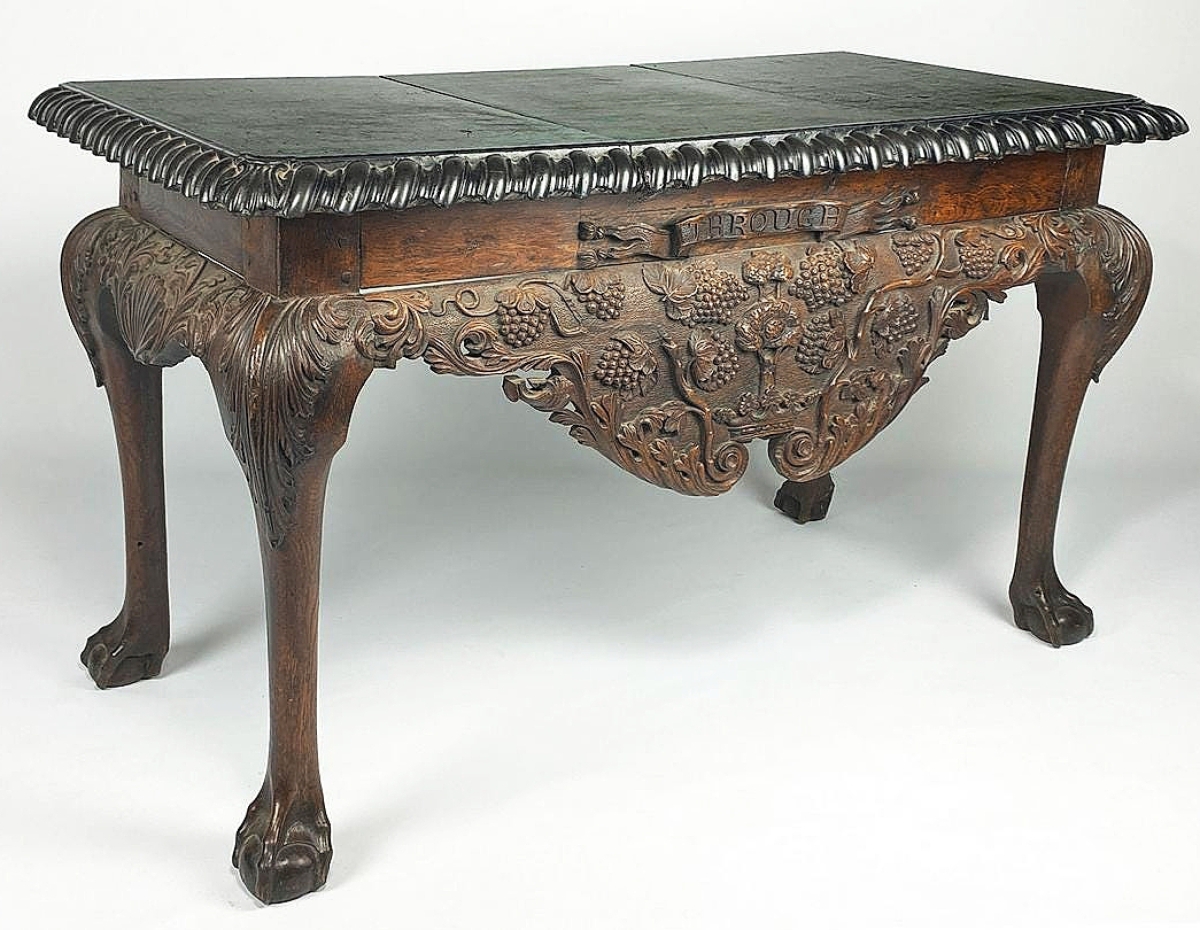 The selection of Irish furniture was led by a circa 1755 George II heavily carved walnut, slate top console table, which realized $21,960. The deep apron was carved with bunches of grapes and vines, and it bore a carved banner above, reading “Through.”