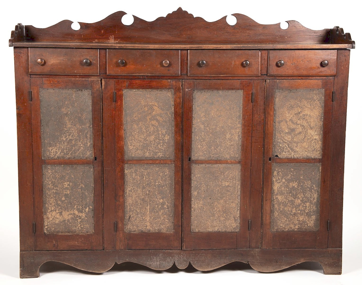 Will Kimbrough said this was a very rare form and illustrated the migration of the pie safe from the back porch to the dining room. The small size and provenance to two known collections helped this Valley of Virginia walnut and cherry sideboard safe with punched tin panels realize $25,085 ($8/12,000).