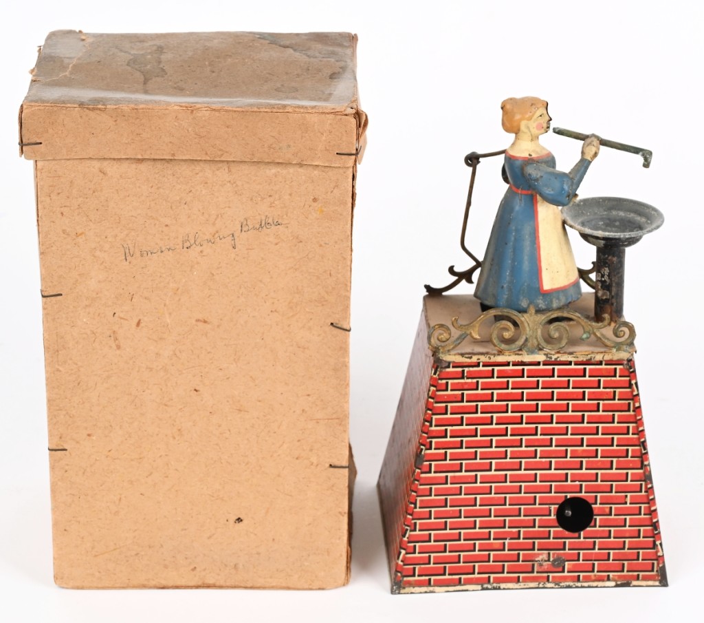 A hand painted and litho tin clockwork Girl Blowing Bubbles from Germany floated to the top of the sale, earning $9,900. Standing on a litho platform, when wound, the girl’s arm moves and she puts the bubble blower in a bowl. A bellows in the platform blows air through the blower and make bubbles.