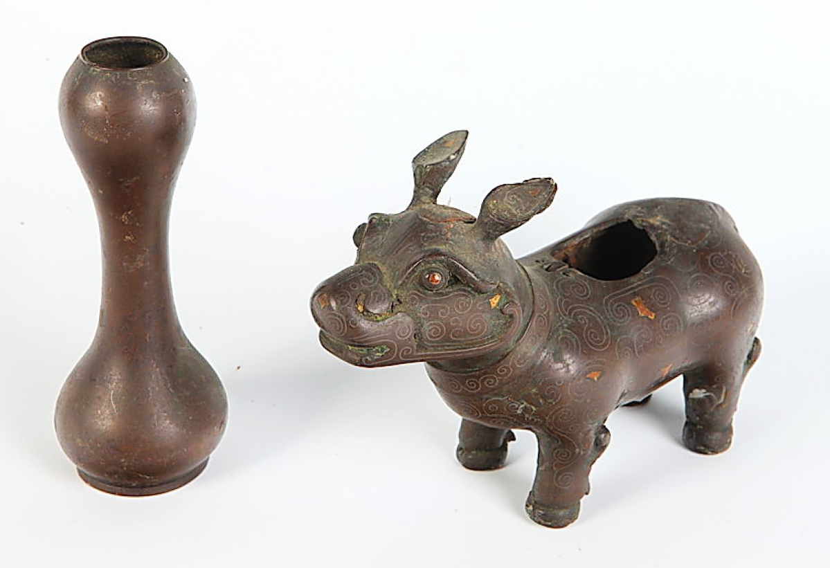 This lot comprising a Chinese fu dog-form censer with gold inlaid highlights and bronze double-gourd shaped vase soared from a $400/600 estimate to sell for $11,590. Both Nineteenth Century, the fu dog was 7 inches long and the vase had a height of 5 inches.