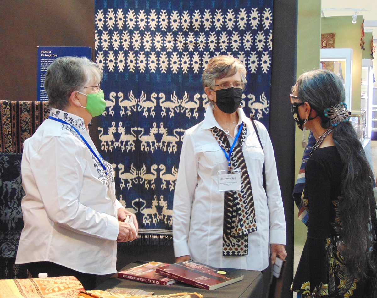 Lin-Chen Willis, a familiar show guest from San Francisco, talks with exhibitors at the Dancing Threads booth during the show’s preview.