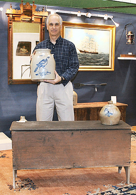 German holds a four-gallon stoneware jar with cobalt decoration of a turkey at The Guilford Antiques Show, 2008. Photo David Smith.