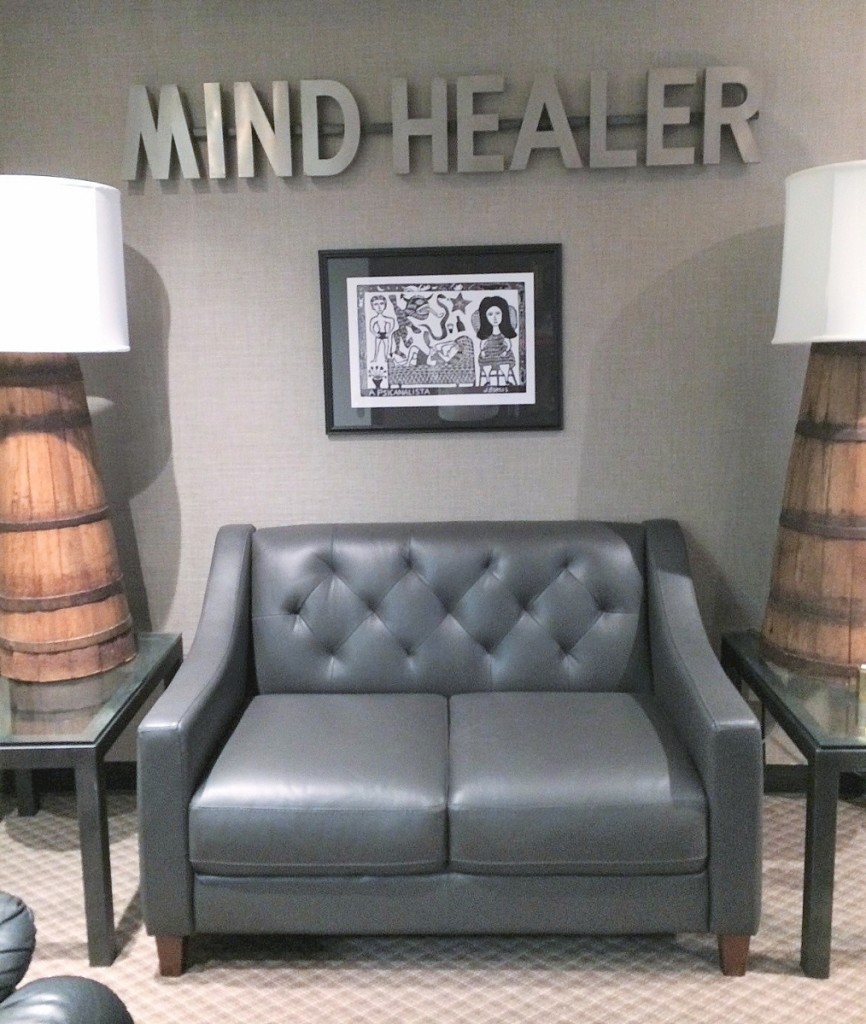 “Mind Healer” sign over a woodcut   depicting a patient in therapy.