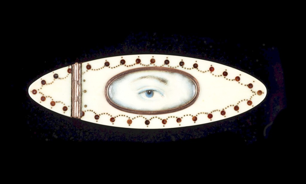 Ivory toothpick case with gold piqué embellishment, hinged lid and burgundy velvet interior,   circa 1890, lady’s blue right eye with blue and gray clouds at the edges.   Dimensions:   by 15/16 by 5/16 inches.