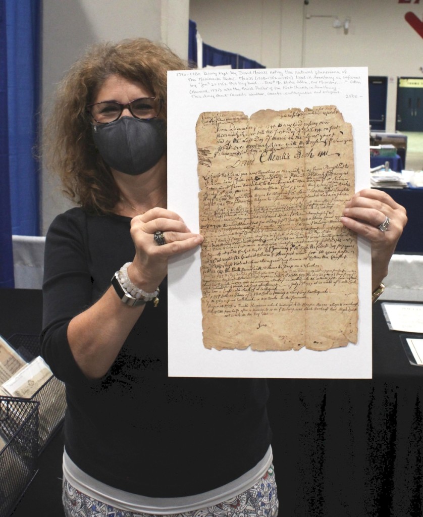 Ann Thorner of Resser-Thorner Antiques, Manchester, N.H., holds up a 1740-80 diary kept by David Merrill noting the natural phenomena of the Merrimac River. Merrill (1708-1782/85) lived in Amesbury. This sheet records weather, comets, earthquakes and eclipses.