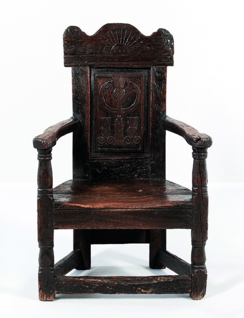 The sale made Seventeenth Century carved armchairs seem common. This one had a shaped and ray-carved crest above the paneled back. Although it showed its age, it earned $8,125.