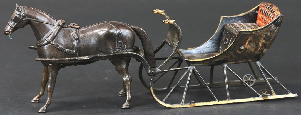 Top among the toys was Ives’ oversized cast iron cutter sleigh with articulated horse and fine paint. The delicate cast iron work is seen in the casting of the horse and the thin rods supporting the sleigh, as well as the eagle head posts off its front. It sold for $25,200.