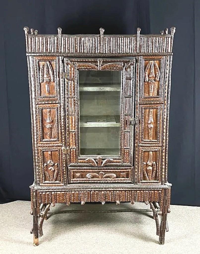 North Carolina furniture maker Reverend Ben Davis’ auction record now stands at $31,200, paid for this china cabinet with chip-carved mountain laurel or rhododendron branches. The work came from the personal collection of George Kylloe, who wrote the book on the artist with The Rustic Furniture of Reverend Benjamin Davis, where this was pictured. Both Davis pieces in the sale sold to the same Adirondack collector.
