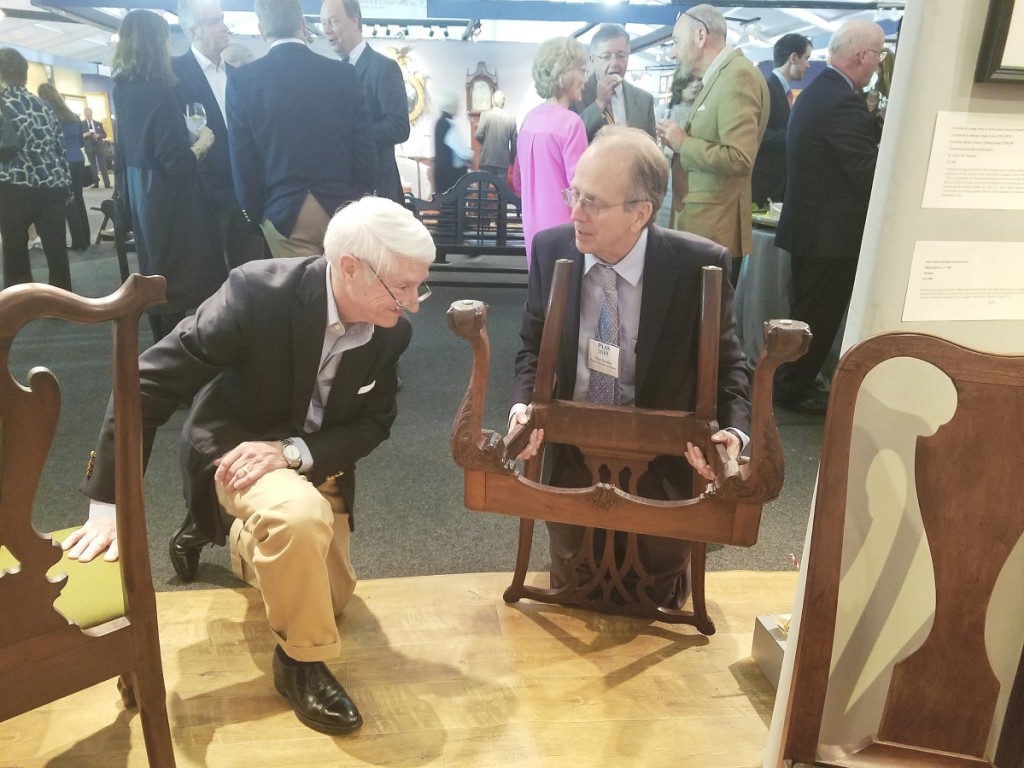 Philip showing a Philadelphia Chippendale chair to a customer at the 2019 Philadelphia Antiques Show. Courtesy Lisa Minardi