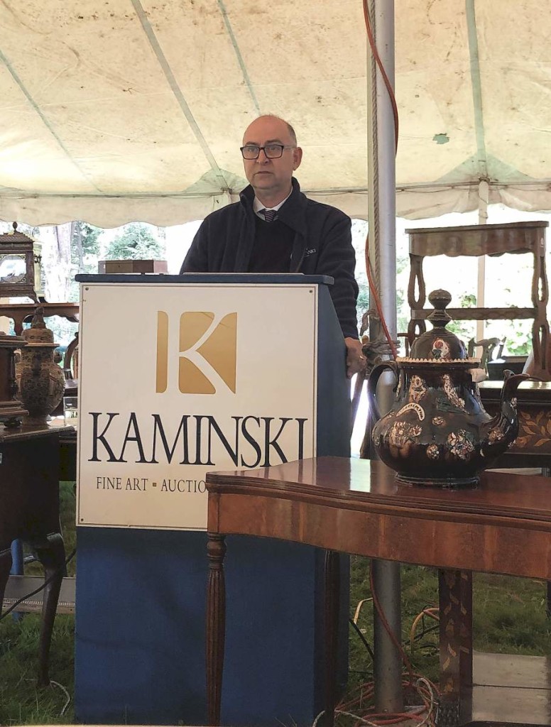 Frank Kaminski at the podium, surrounded by some of the things being sold.