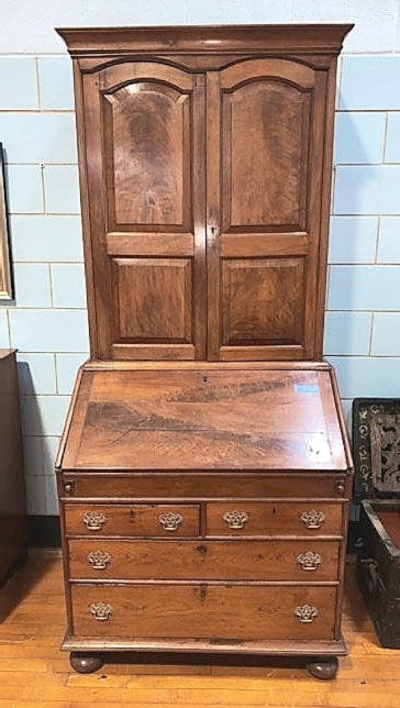 Top lot honors went to this early walnut secretary desk that was probably made in Philadelphia in the early Eighteenth Century and featured tombstone paneled bookcase doors, a larger than usual base section and compressed ball feet. A buyer from Philadelphia, bidding in the room, pushed it to $8,338.