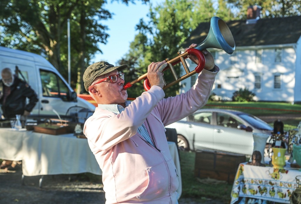 John Gintoff of Gintoff Displays, East Hampton, blows a painted wood trumpet he believes was a store display.