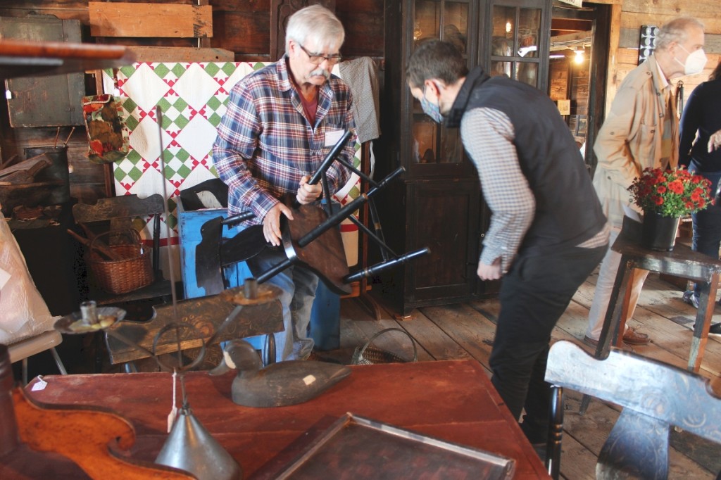 Mark Wheaton, Maria’s Pond Antiques, had a gold star on his badge that denoted his longevity with the show. Here he is seen discussing the merits of a black chair with a potential buyer. The number of red tags in his booth suggests he was having a good show. Pattersonville, N.Y.