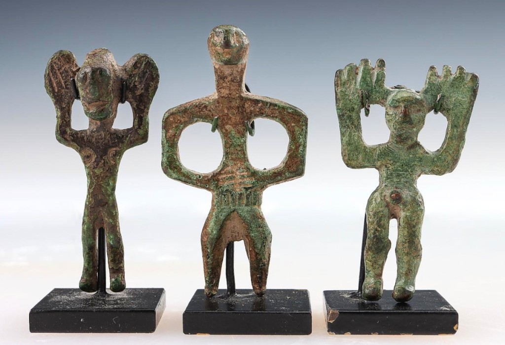 Enormous palms turned to face outward, with hands raised in the classic style of the region, three ancient Dagestan bronze idols from the Kaitag region took $3,000.