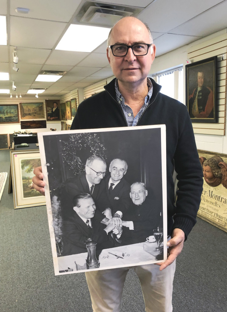 Frank Kaminski holds a photo of Anthony Athanas with then Massachusetts governor John Volpe, Cardinal Cushing and a third person.