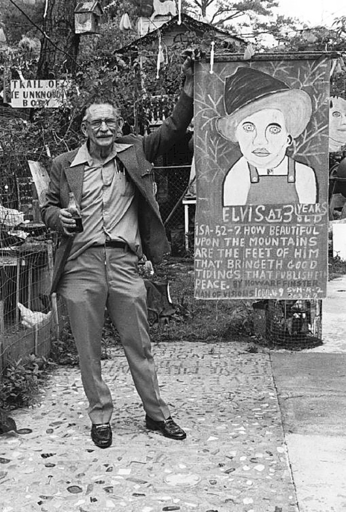 Howard Finster with his baby Elvis banner, Paradise Garden, 1981. Photo by Tom Patterson.