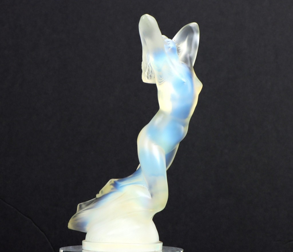 An Art Deco opalescent glass hood ornament of a nude female, with molded “R. Lalique” and “France” at the base, took $12,000.